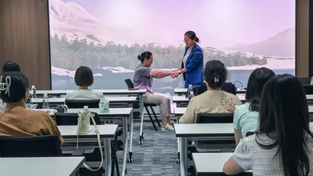 A vocal instructor explains singing and breath-control techniques during the NSD Electrical workshop.