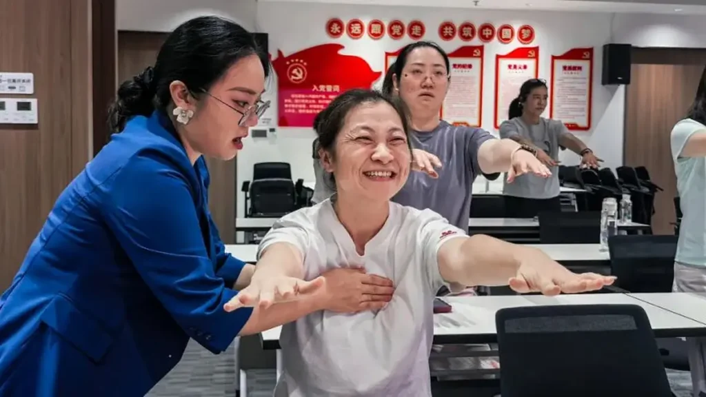 Female employees participate in a guided breathing and relaxation exercise at NSD Electrical.